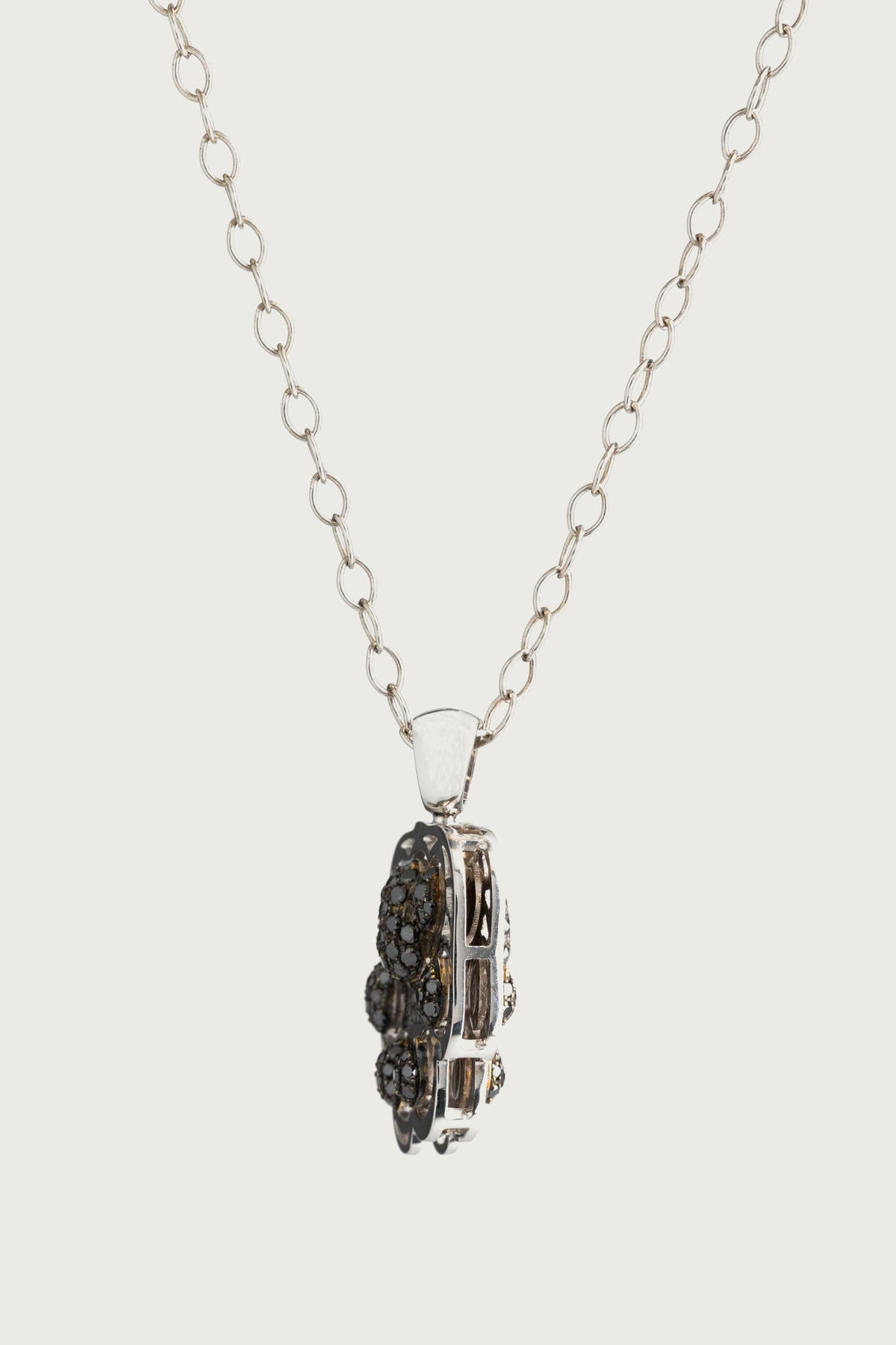 Pardo turns on its chain and shows its edge: the openwork white gold frame and the pads of black diamonds.