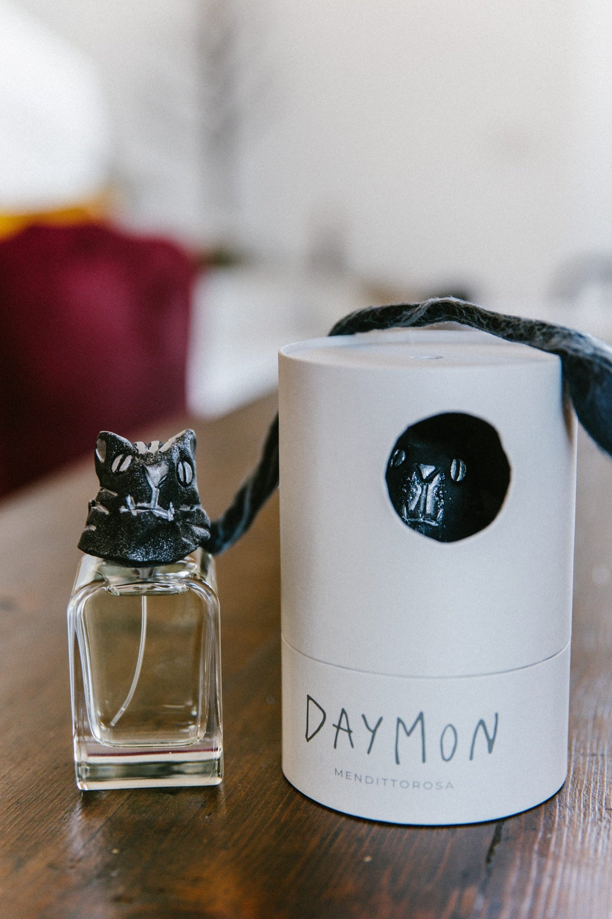 Il profumo Daymon: il flacone con la sua testa scolpita e dipinta a mano, accanto all'astuccio.